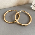 Polished large golden round hoop earrings with secure hinged clasp on grey fabric - Gold Smooth Polished (6cm)