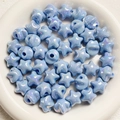 Macro detail of macaron blue pearlescent star beads for DIY handmade jewelry crafts - Blue