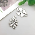 Detail of silver-plated four-leaf clover charms in smooth and textured antique finishes - Four-leaf Clover 11x18mm