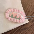 Close-up of handmade crochet flower hair clip with pink blossoms and green leaves - Pink Flower Hair Clip