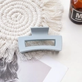 Close-up of light blue rectangular matte hair claw clip on a woven mat with a magazine - Medium Matte Square Claw-Light Gray