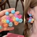 Primer plano de pendientes de flores de rafia con pétalos de malla de colores vibrantes. - Azul Multicolor