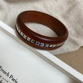 Vue détaillée d'un bracelet en bois vintage avec des rivets argentés sur une boîte blanche - Café Foncé Avec Rivets Carrés