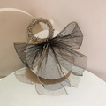 Détail d'un chouchou en tulle noir avec nœud à pois dorés et perles de cristal sur socle - Boucle noire avec ruban noir