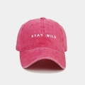 Dettaglio del ricamo bianco STAY WILD su cappellino da baseball rosa lavato - Rosa Rosso