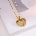 Elegante goldene Halskette mit hohlem Herzanhänger und Zirkonia auf weißem Buchhintergrund - Modell 23525