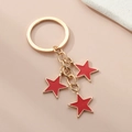 Détail d'un porte-clés en alliage doré clair avec trois étoiles en émail rouge et finition lisse - Pentagramme / Rouge