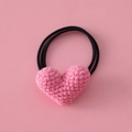 Primer plano de coletero de corazón de ganchillo rosa con textura de punto suave y elástico - Corazón Rosa