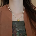 Vintage green beaded pearl necklace with gold lock pendant on model neck - Style 23 Necklace - Gold Lucky Bag