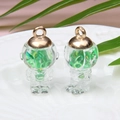 Detail of transparent astronaut pendants with green sequins inside a glass sphere - Astronaut / Grass Green