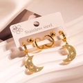 Detalle de pendientes de aro de acero dorado con colgantes de estrella y luna en base - Oro/Conjunto Mate de Estrella Luna