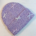Detailed close-up of purple knit beanie featuring cute bow accents on soft plush texture - Light Purple