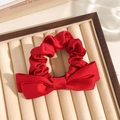 Red satin floral scrunchie with a large bow detail displayed on a velvet tray - Big Red Bow