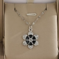 Collier à pendentif floral avec pétales en émail noir et cristaux sur une chaîne argentée - Motif floral