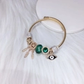 Vergulde armband met dromenvanger, boze oog bedeltjes en groene kristallen - Groen