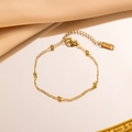 Elegante 18K vergulde kralenarmband met verstelbare ketting op een zijden achtergrond - Parelarmband / Goud