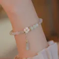 Elegant beaded bracelet featuring light green jade-style beads and a white clover charm - S187-bamboo Joint Bracelet With Added Splendor #sz449