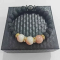 Black lava stone beaded bracelet with pink accents and golden spacers on a gift box - Lava with Marble and Hematite Beads
