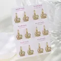 Macro detail of six pairs of gold crown earrings with pave white zircons on a display card - 14K Gold Plated Crown Hoop Earrings Set