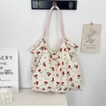Détail du sac cabas en toile avec imprimé cerise et anses en corde rose en situation - Mousseline Cerise Beige Blanc