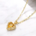 Collier cœur doré avec cristal jaune et zircons blancs étincelants sur fond en marbre blanc - Orange