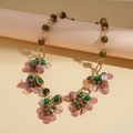 Detalle de collar bohemio con cuentas de piedra verde y dijes de concha púrpura en oro - Collar con Colgante de Cuentas - Púrpura