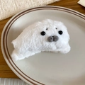 Close-up of white plush seal hair claw clip with black bead eyes on a ceramic plate - Claw Clip - White