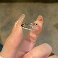 Detail of silver crisscross T-motif ring with pave zircon stones on hand - Cross T Letter Shape / Silver