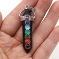 Détail d'un pendentif chakra en obsidienne noire avec sept pierres d'énergie dans la main - 7 Chakra Agate Noire
