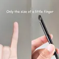 Macro detail of compact round concealer brush tip compared to a pinky finger size - Pinky Concealer Brush