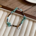 Detalle de pulsera de cuentas con turquesas y colgante de plata grabado con sol - Pulsera - Azul & Marrón