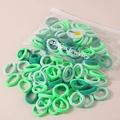 Sortierte grüne elastische Haargummis in einem transparenten Beutel mit Gänseblümchen. - 50 Stück/Packung (Beutel) / Grüntöne