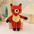 Handmade crochet fox plush toy in orange and beige yarn for kids, sitting on a gift box - 25cm Fox