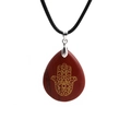 Close-up of red stone teardrop pendant featuring a golden Hamsa Hand on a black woven cord - Red Stone/Wax Cord
