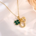 Detail of gold necklace featuring green clover, crystal heart, and horseshoe charms - Gold Heart Clover Style