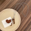 Close-up of vintage necklace featuring brown leather heart, wooden beads and silver bird charm - Style 8 Necklace - Coffee