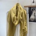 Detail of a lightweight yellow linen scarf with delicate lace patterns on a white top - Yellow