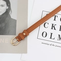 Cintura sottile da donna in pelle marrone caramello con fibbia dorata su rivista - Cammello