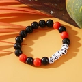 Beaded bracelet with black and orange stones and white letter beads on orange background - Halloween KCRT Letters Black Orange