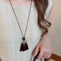Détail macro d'un pendentif trapèze en bois vintage sur un collier à glands pour femme - 57# Collier-Café
