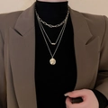 Detalle de collares dorados en capas con colgante en relieve sobre modelo en cuello alto - Estilo de Cadena Apilada de Tres Capas (31#)
