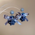Detail of blue plaid fabric star pendant and ribbon bow on elegant drop earrings - Gray