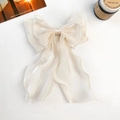 Détail d'un nœud papillon en organza crème avec rubans fluides et texture nacrée - Nœud en Ruban de Soie Brillant / Abricot