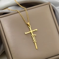 Close-up of golden cross pendant featuring a cursive love script on a jewelry box - LOVE / Gold