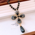Dettaglio di collana vintage con perline e ciondolo a croce dorata con pietre a goccia - Collana (Oro-Nero-Goccia d'acqua)