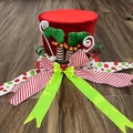 Details von rotem Weihnachtsbaum-Zylinder mit Elfenbeinen und grüner Glitzerschleife - Hexe Elfenbeine Stil
