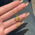 24K gold plated necklace with rocking horse pendant and lucky charm on blue denim background - Gold