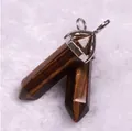 Macro shot of tiger eye stone hexagonal column pendants with silver metal clasps on white fur - Tiger's Eye
