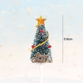 Detailed view of a 5.6cm green flocked Christmas tree cake topper with Merry Christmas sign - Flocked Cedar Tree Style