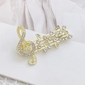 Close-up of golden music note brooch with shimmering rhinestones and polished finish - Gold Musical Note